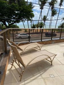 una silla en el balcón con vistas al océano en Lindo Apartamento à Beira Mar, en João Pessoa