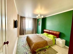 een slaapkamer met groene muren en een bed bij 4х комнатные апартаменты in Pavlodar