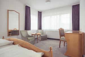 um quarto de hotel com uma cama, uma mesa e cadeiras em Hotel Schwan em Oestrich-Winkel