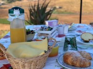 a table with a basket of bread and a bottle of juice at Helimos Segesta in Brucanuova