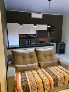 un sofá marrón en una habitación con cocina en Sunshine Chalé Brasília-DF en Brasilia