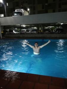 un uomo che nuota in una piscina di notte di Cúcuta apartamento completó en condominio n11 a Cúcuta