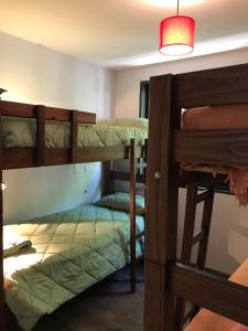 a room with three bunk beds and a lamp at Lapacho Hostel Salta Coliving in Salta