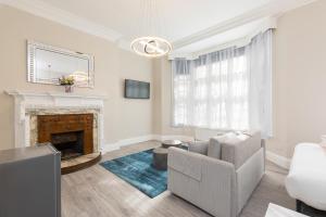 uma sala de estar com um sofá e uma lareira em Air Conditioned Apt High St Kensington em Londres