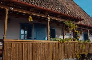 Bartoştana的住宿－Székelyföld ,Siklódi Kő Vendégház, Tornácosház，一座带木栅栏和蓝色门的房子