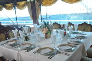 a table with plates and silverware on a white table cloth at Hotel Brod Panini Veles in Veles