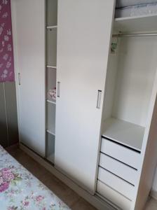 armario con armarios blancos y cama en Lindo Apartamento à Beira Mar, en João Pessoa