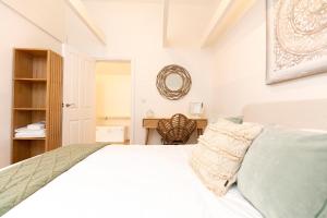 a white bedroom with a bed and a desk at Whitstable Wishes, a Stylish Seaside Retreat, Whitstable with Parking Space in Whitstable