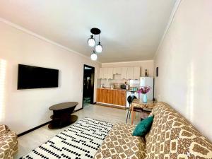ein Wohnzimmer mit einem Sofa und einem Tisch in der Unterkunft 2х комнатные апартаменты рядом с Центральной Мечетью in Pawlodar