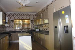 a kitchen with a stainless steel refrigerator at Masbella Hotel Ltd 