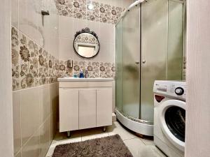 łazienka z umywalką i pralką w obiekcie 1 комнатные апартаменты w mieście Pawłodar
