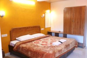 a bedroom with a large bed and a cabinet at Hotel Sri Balaji in Ooty