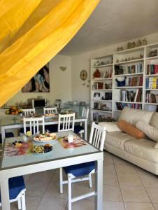 een woonkamer met een tafel en stoelen en een bank bij Casa Vacanza Le Fresie in Nuoro