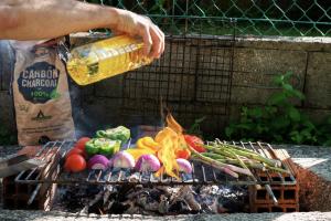 a person is cooking food on a grill at Meiga Backpackers Hostel in Santiago de Compostela
