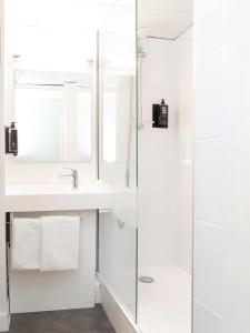 メスにあるアイビス メッツ センター カテドラルの白いバスルーム(ガラス張りのシャワーブース、シンク付)