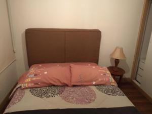 Una cama con un edredón rosa encima. en El Limonal, en Quito