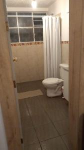 La salle de bains est pourvue de toilettes et d'un rideau de douche. dans l'établissement El Limonal, à Quito