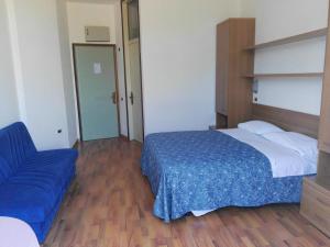 マネルバ・デル・ガルダにあるHotel La Romanticaのベッドルーム(ベッド1台、青いソファ付)