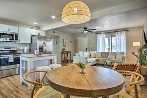a kitchen and living room with a wooden table and chairs at Lovely Tucson Home about Walk to Reid Park Zoo! in Tucson