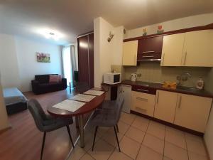 a kitchen and living room with a table and chairs at Apartament studio in Zakopane