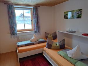 um quarto com duas camas e uma janela em Ferienwohnung Annele em Hittisau