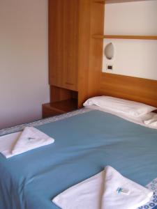 a bed with two white towels on top of it at Hotel La Romantica in Manerba del Garda