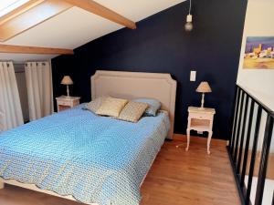 een slaapkamer met een blauw bed en 2 nachtkastjes bij Hauts de St pierre in Fayence