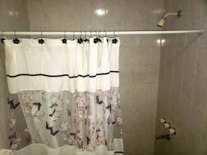 einen Duschvorhang mit Blumenmuster im Bad in der Unterkunft Excelente departamento tranquilo in Ushuaia