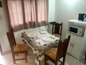 einen Esstisch mit einem Tisch und 2 Stühlen in der Unterkunft Excelente departamento tranquilo in Ushuaia