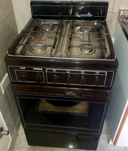 einen Backofen mit einem schwarzen Kochfeld in der Küche in der Unterkunft Excelente departamento tranquilo in Ushuaia