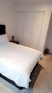 a bedroom with a large bed with white sheets at Stunning 1 Bedroom Apartment in London
