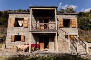 una casa de piedra con una escalera que conduce a ella en Πέτρινη κατοικία με υπέροχη θέα στο όρος Κόζιακα. 