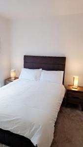 a bedroom with a large white bed with two night stands at Stunning 1 Bedroom Apartment in London