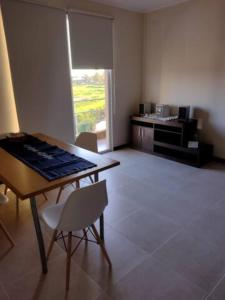 a room with a table and chairs and a kitchen at Residencia Merlo in Rafaela