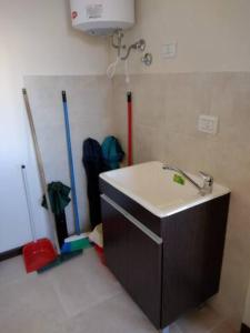 a kitchen with a sink and two mop at Residencia Merlo in Rafaela