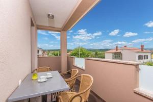 einen Tisch und Stühle auf einem Balkon mit Aussicht in der Unterkunft Mandy & Mia in Novigrad Istria