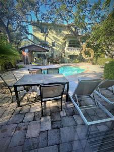 a patio with a table and chairs next to a pool at Siesta Key Bay View in Siesta Key