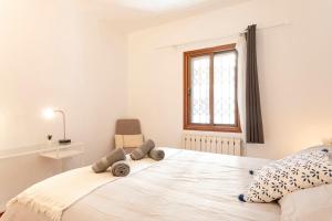 a bedroom with a large white bed with a window at Barcelona Beach Home in Barcelona