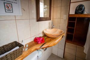 a bathroom with a wooden sink on a wooden counter at CHEZ MARIA GORETTI HOTEL in Hanga Roa