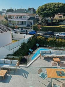 een patio met een zwembad en tafels en stoelen bij Luna House in Cascais