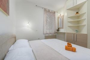 a bedroom with a bed with an orange towel on it at Apartment Ida in Novigrad Istria