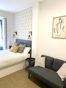 a bedroom with a bed and a couch at Apartamentos Fuencarral in Madrid