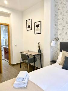 a bedroom with a desk and a bed and a table at Apartamentos Fuencarral in Madrid