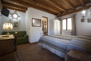 een slaapkamer met een bed en een groene bank bij Affittacamere Mariella in Levanto