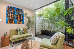 a living room with two chairs and a large window at Period 3-Bed Maisonette next to the City of London in London