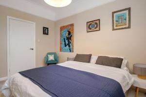 a bedroom with a large bed with a blue blanket at Period 3-Bed Maisonette next to the City of London in London