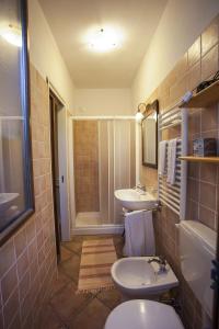 ein Badezimmer mit zwei Waschbecken, einem WC und einer Dusche in der Unterkunft Affittacamere Mariella in Levanto