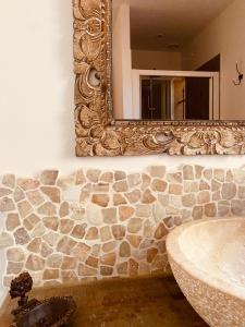 een badkamer met een stenen muur en een spiegel bij Le Mas du Soleil in Sainte-Maxime