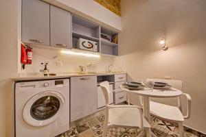 een keuken met een wasmachine en een tafel met stoelen bij 33 Sally Port in Valletta