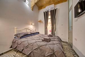 een slaapkamer met een bed en een groot raam bij 33 Sally Port in Valletta